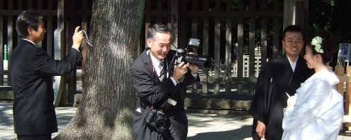 Photo of an amateur photographer taking a photo of a professional photographer taking a photo of a newlywed couple in Japan